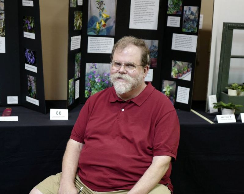 Ray Ruger, Packet co-Chair, in front of the Educational Division exhibits